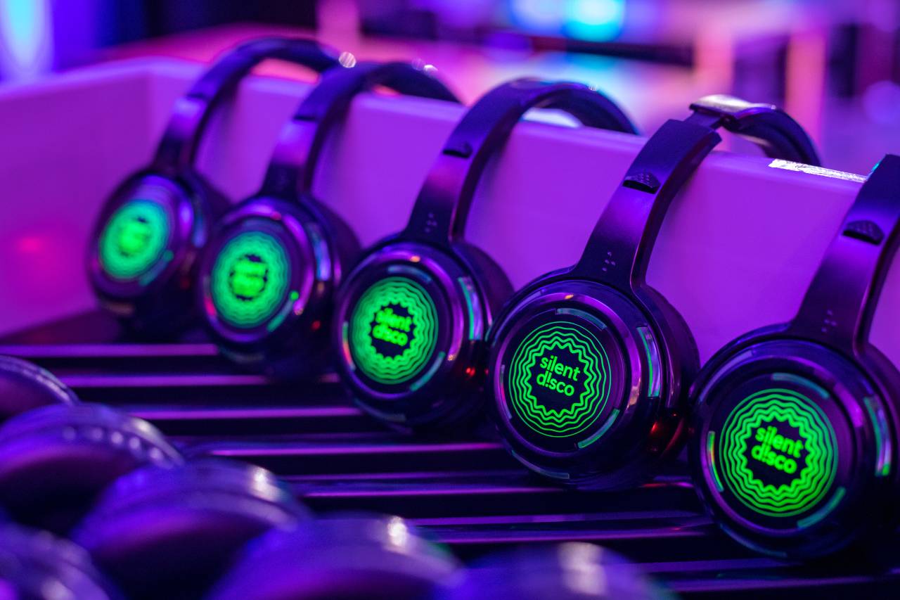 Row of black headphones with silent disco logo in green